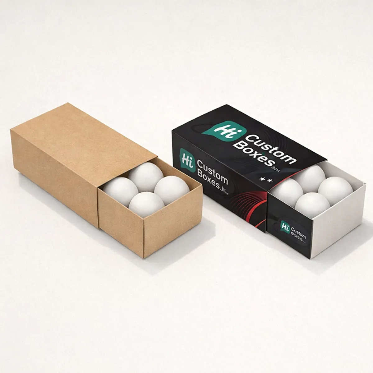 Two sliding drawer boxes, one kraft brown and one branded black, each containing four white balls. class=